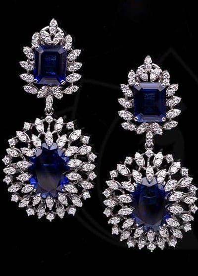 Sparkling diamond earring with blue quartz in the middle.