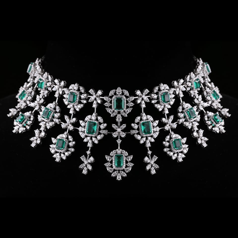 Beautiful diamond necklace with emerald stone work worn on a black mannequin