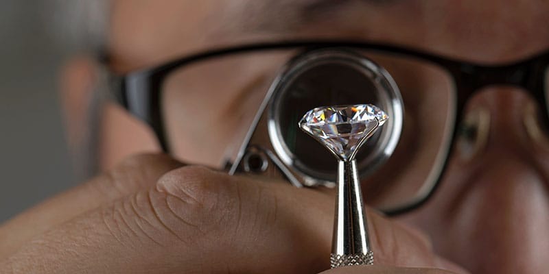 A craftsman checking the quality of a diamond.
