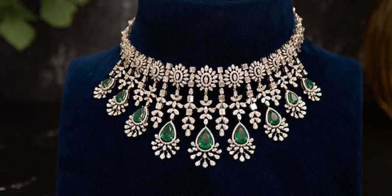 Beautifully crafted Infinite Glamour Diamond Choker Necklace studded with diamonds and green semiprecious stones.