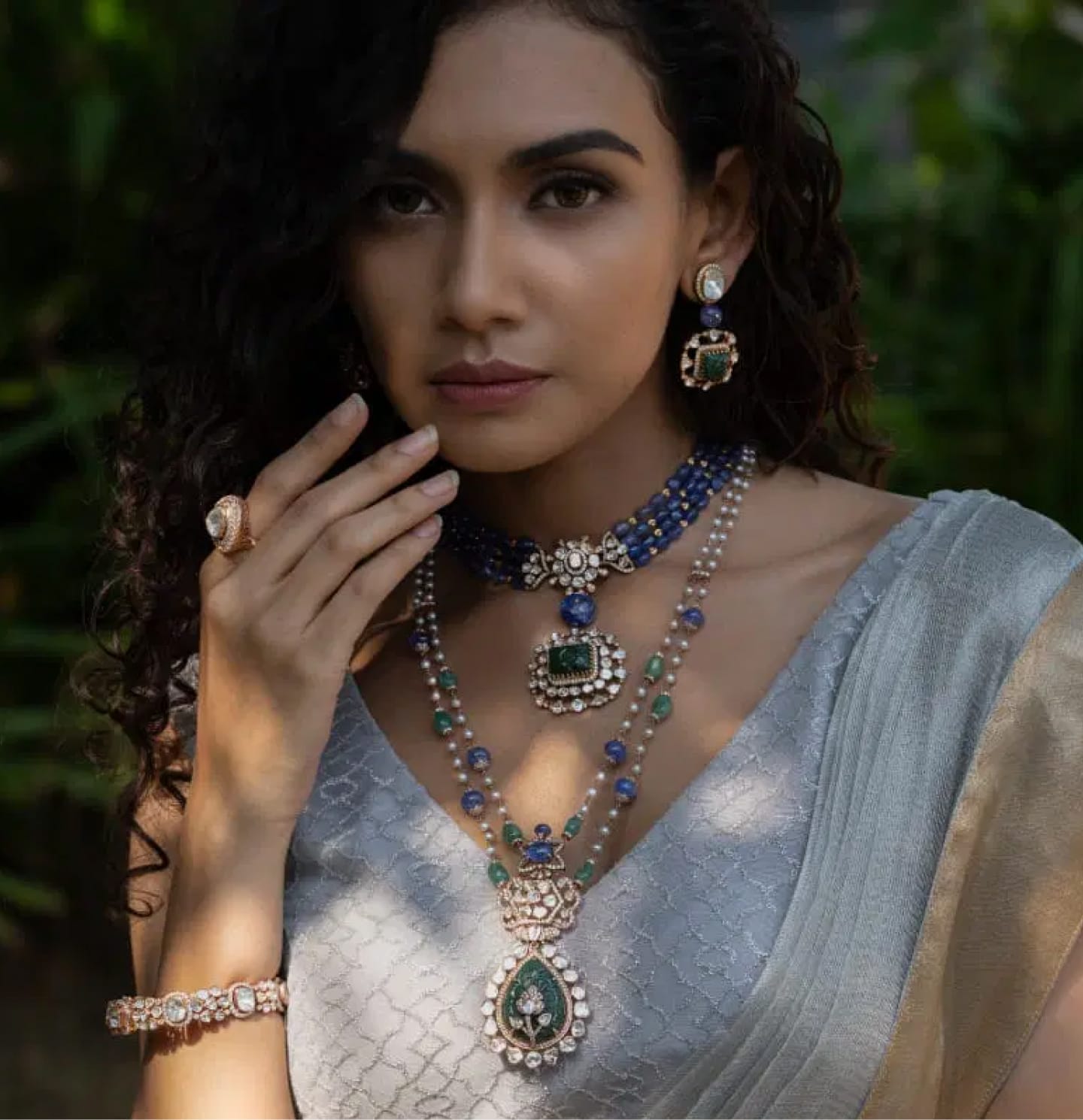 A close-up shot of a modern maid adorning herself with stunning uncut diamond polki jewellery with precious gemstones from the Fazza Collection by Khwaahish.